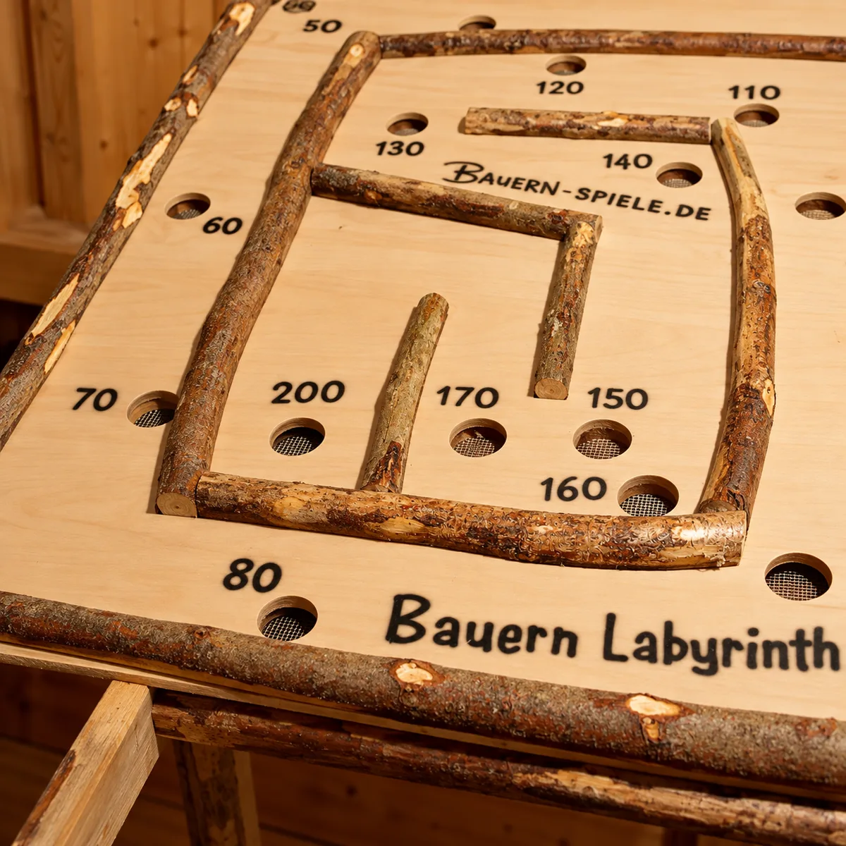 Bauern Labyrinth: Spieloberfläche aus hellem Holz mit Begrenzungen aus Naturästen und nummerierten Punktefeldern