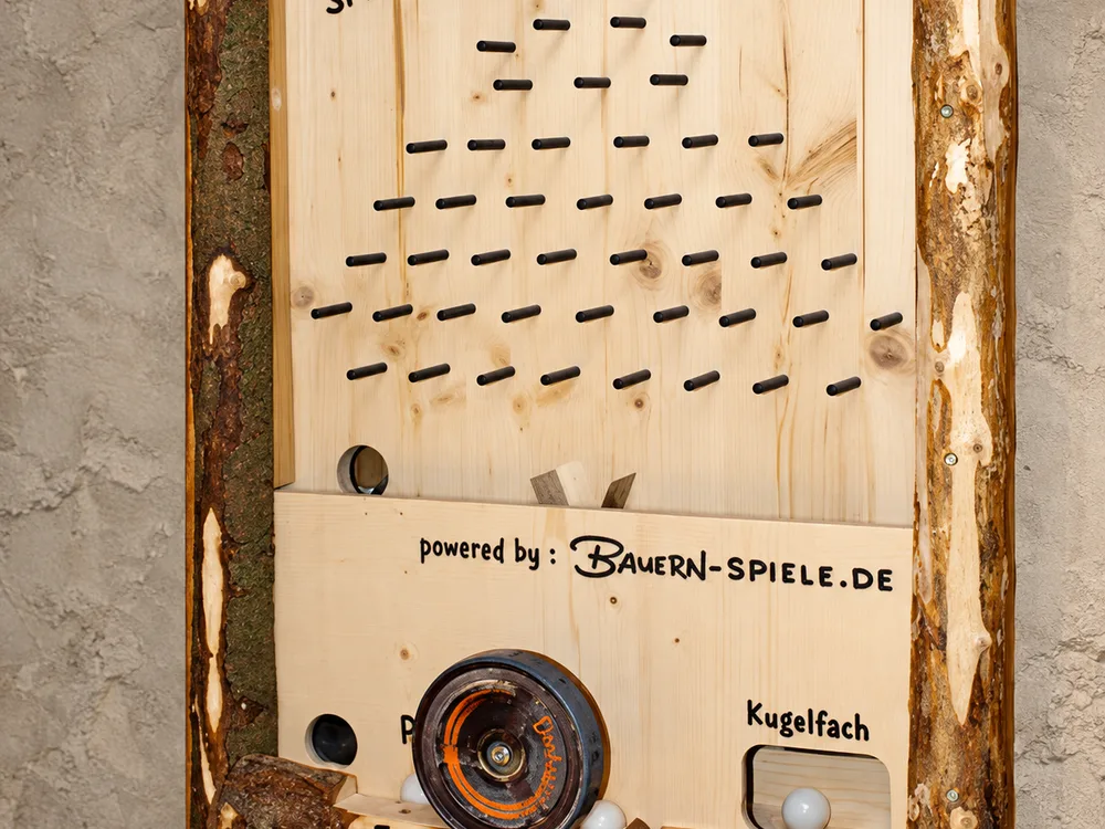 Detailansicht des Bauern-Spielomat: Nagelbrett-Labyrinth, Drehrad und Kugelfach mit zwei Kugeln